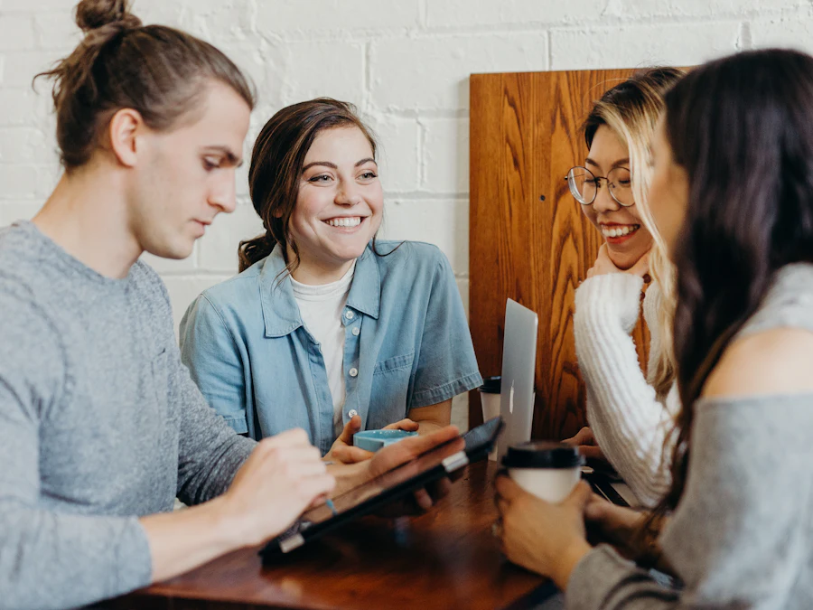 Colleagues laughing around laptops at a table